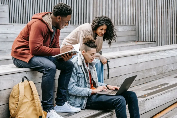 Étudiant tapant ses identifiants de connexion sur un ordinateur portable à un bureau