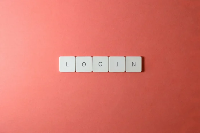 Mains d'une personne tapant un identifiant sur un clavier devant un écran affichant un formulaire de connexion webmail Mains d'une personne tapant un identifiant sur un clavier devant un écran affichant un formulaire de connexion webmail
