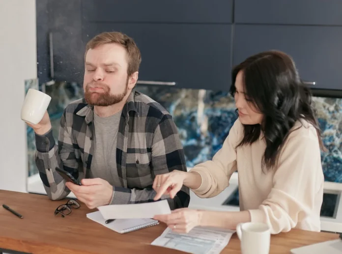 Couple examinant des documents d'assurance-vie et de planification financière à la maison