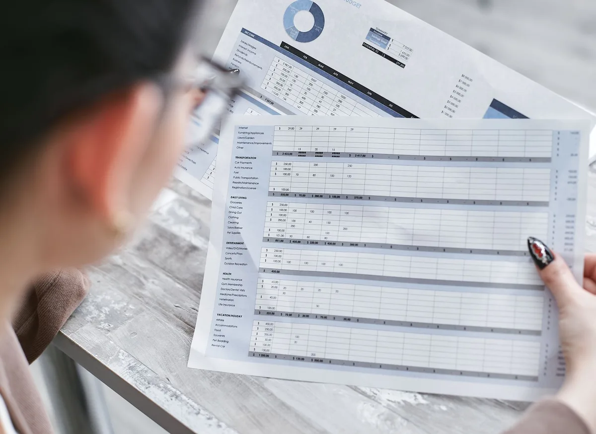 Personne établissant un inventaire de son patrimoine avec documents et liste d'actifs