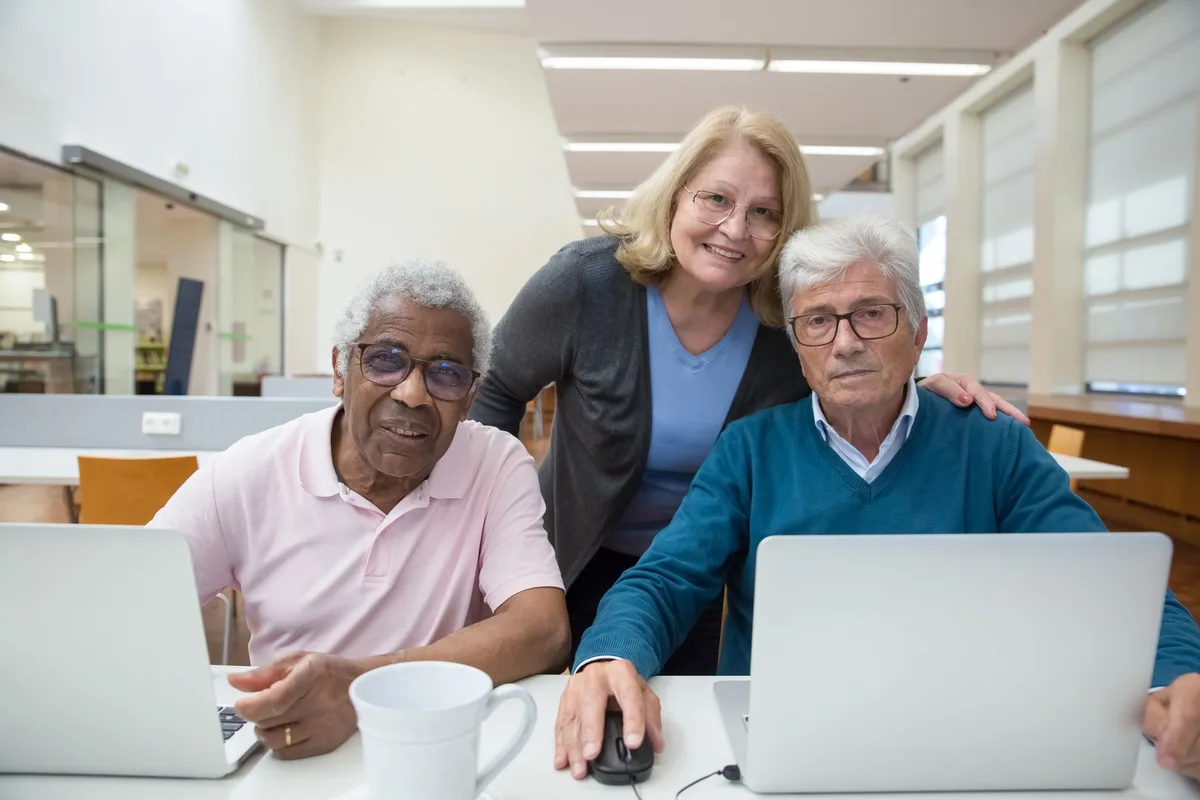 Groupe d'adultes âgés en formation informatique dans une salle de cours