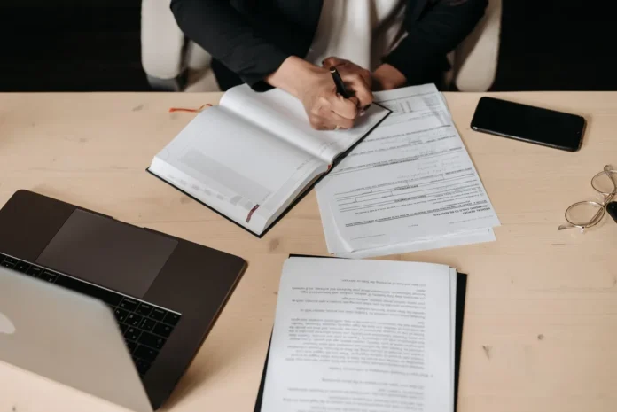 Documents et cartes bancaires professionnelles organisés sur un bureau avec un ordinateur portable Documents et cartes bancaires professionnelles organisés sur un bureau avec un ordinateur portable