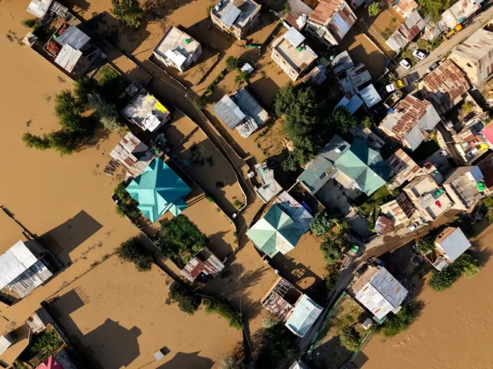 Atelier artisanal inondé avec matériel endommagé et personne évaluant les dégâts Atelier artisanal inondé avec matériel endommagé et personne évaluant les dégâts