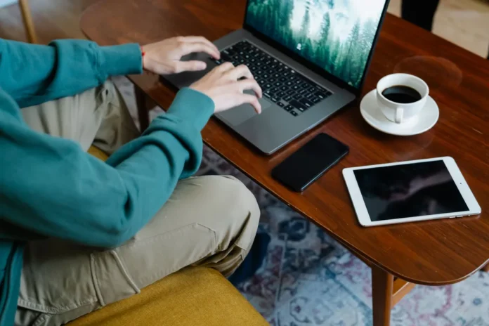 Mains d'une personne tapant sur un clavier avec documents et calculatrice sur un bureau