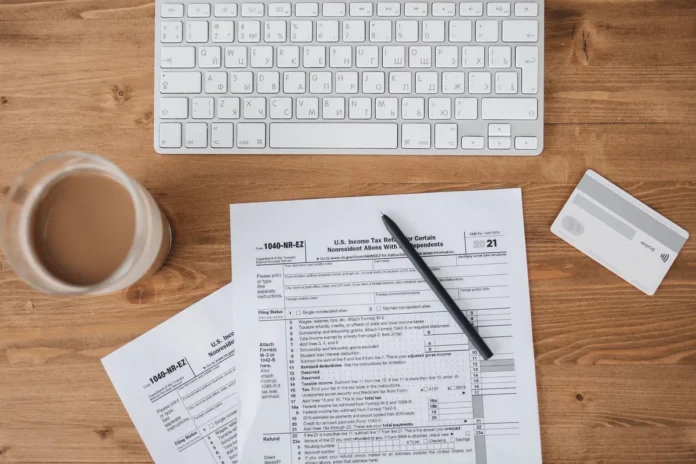Formulaires administratifs et documents fiscaux remplis sur un bureau avec calculatrice Formulaires administratifs et documents fiscaux remplis sur un bureau avec calculatrice