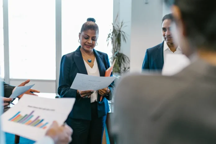 Femme enceinte en entretien professionnel avec documents et dossiers sur le bureau Femme enceinte en entretien professionnel avec documents et dossiers sur le bureau