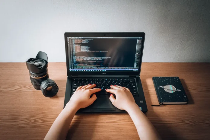 Un développeur travaille sur son ordinateur avec notes et liste de vérification pour tester une extension.