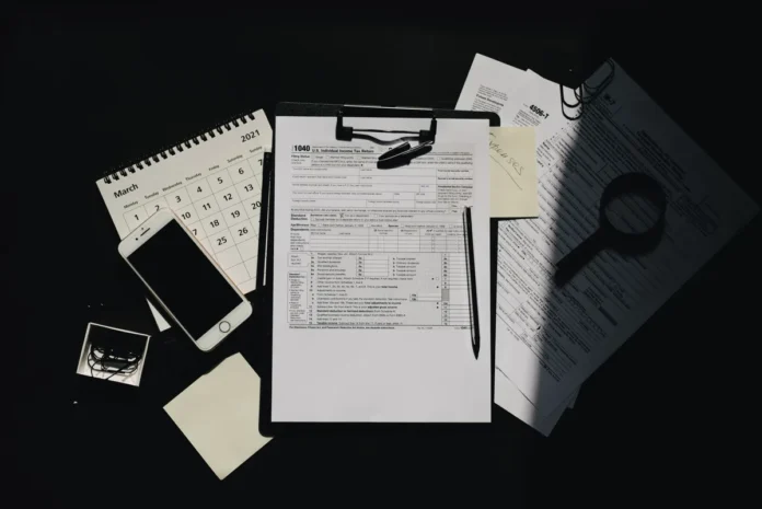 Bureau avec documents fiscaux, reçus et justificatifs de dépenses professionnelles, calculatrice et stylo Bureau avec documents fiscaux, reçus et justificatifs de dépenses professionnelles, calculatrice et stylo