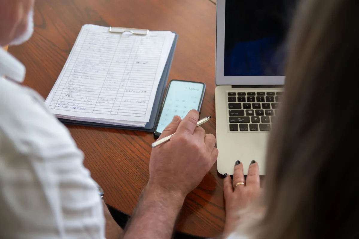 Artisan travaillant sur des documents administratifs à son bureau avec un ordinateur