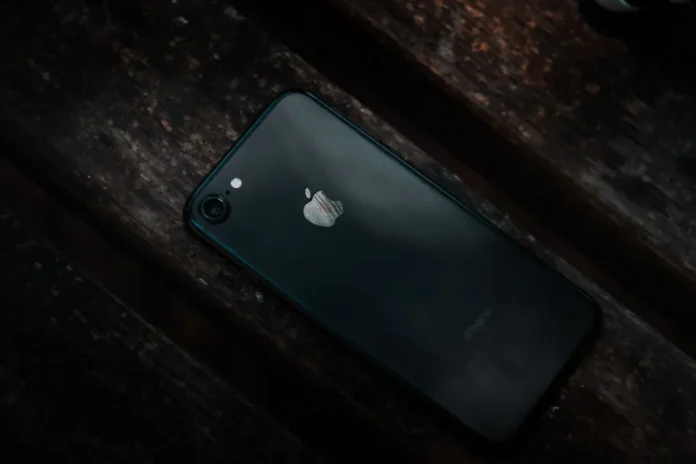 Mains tenant un iPhone en bon état, montrant l'écran et l'arrière de l'appareil