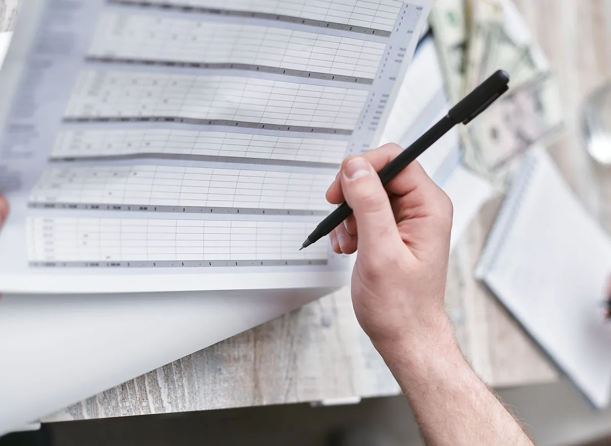 Équipe réunie autour d'une table de réunion examinant des projections financières et des documents d'aide.