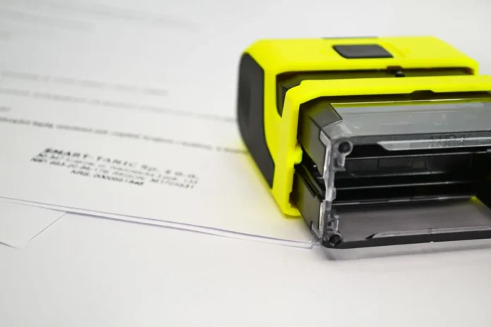 Mains anonymes signant un avenant sur une table avec clés et documents de location