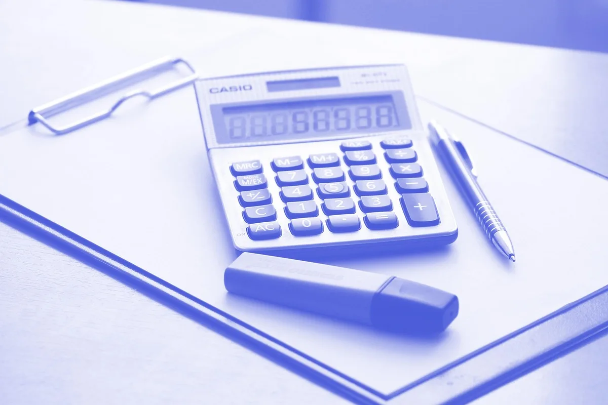 Experts examinant des documents de valorisation avec une calculatrice