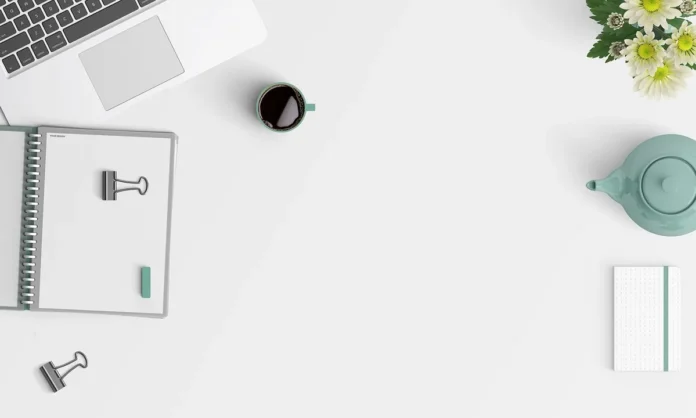 Mains sur un bureau ensoleillé signant un contrat d'alternance avec calendrier à côté Mains sur un bureau ensoleillé signant un contrat d'alternance avec calendrier à côté