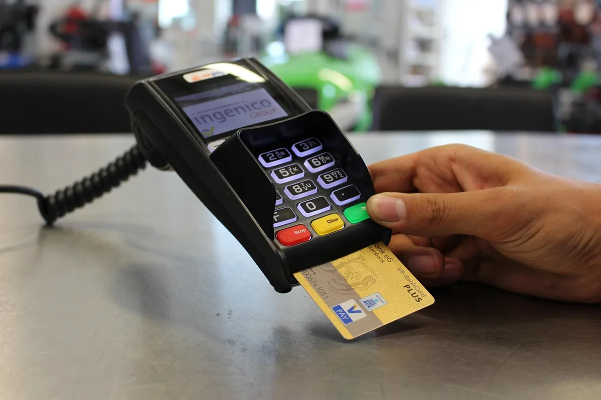 Reçu de paiement par carte posé à côté d'un terminal de paiement