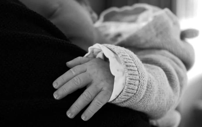 Mains d'un parent tenant délicatement un nouveau-né, lumière douce et naturelle. Mains d'un parent tenant délicatement un nouveau-né, lumière douce et naturelle.