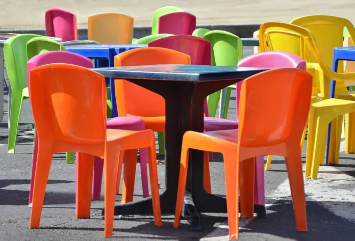 Terrasse vide d'un petit café de village avec caisses de produits locaux et panneau d'information