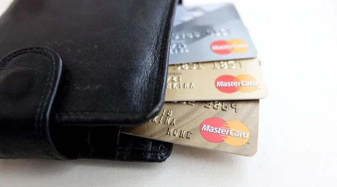 Terminal de paiement sur un comptoir de boutique avec papiers et mains en pleine journée Terminal de paiement sur un comptoir de boutique avec papiers et mains en pleine journée