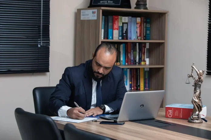 Bureau lumineux avec dossiers et mains feuilletant des documents sur une table Bureau lumineux avec dossiers et mains feuilletant des documents sur une table
