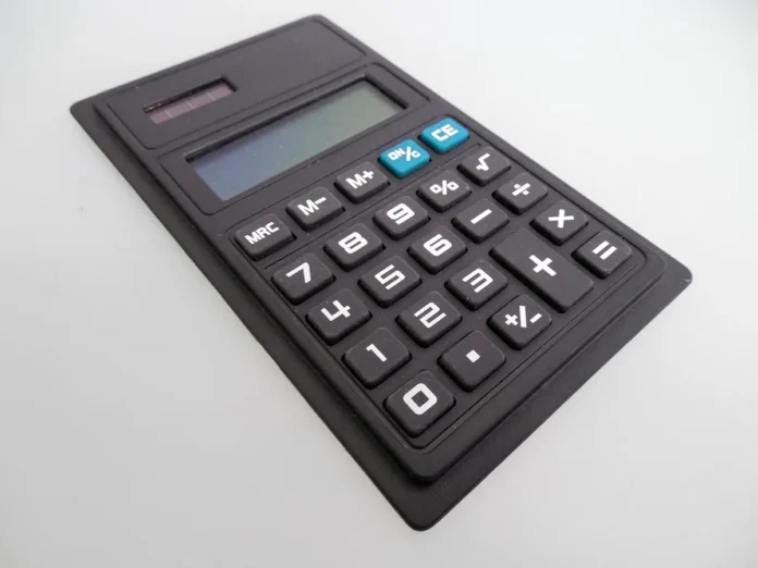 Bureau avec documents financiers, calculatrice et ordinateur portable affichant des chiffres de chiffre d'affaires Bureau avec documents financiers, calculatrice et ordinateur portable affichant des chiffres de chiffre d'affaires