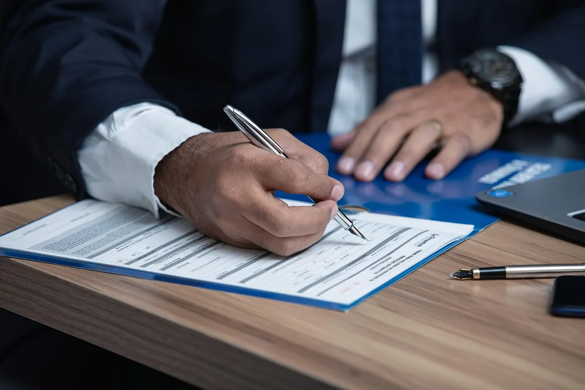 Avenant signé posé sur une table avec deux mains visibles
