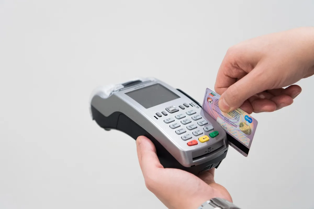 Main saisissant un code PIN sur un terminal de paiement en plein jour