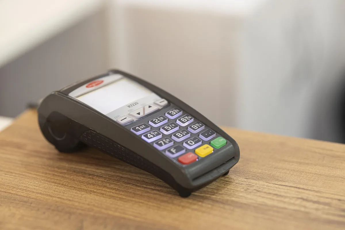 Différents terminaux de paiement posés sur un comptoir, comparant modèles fixes et portables