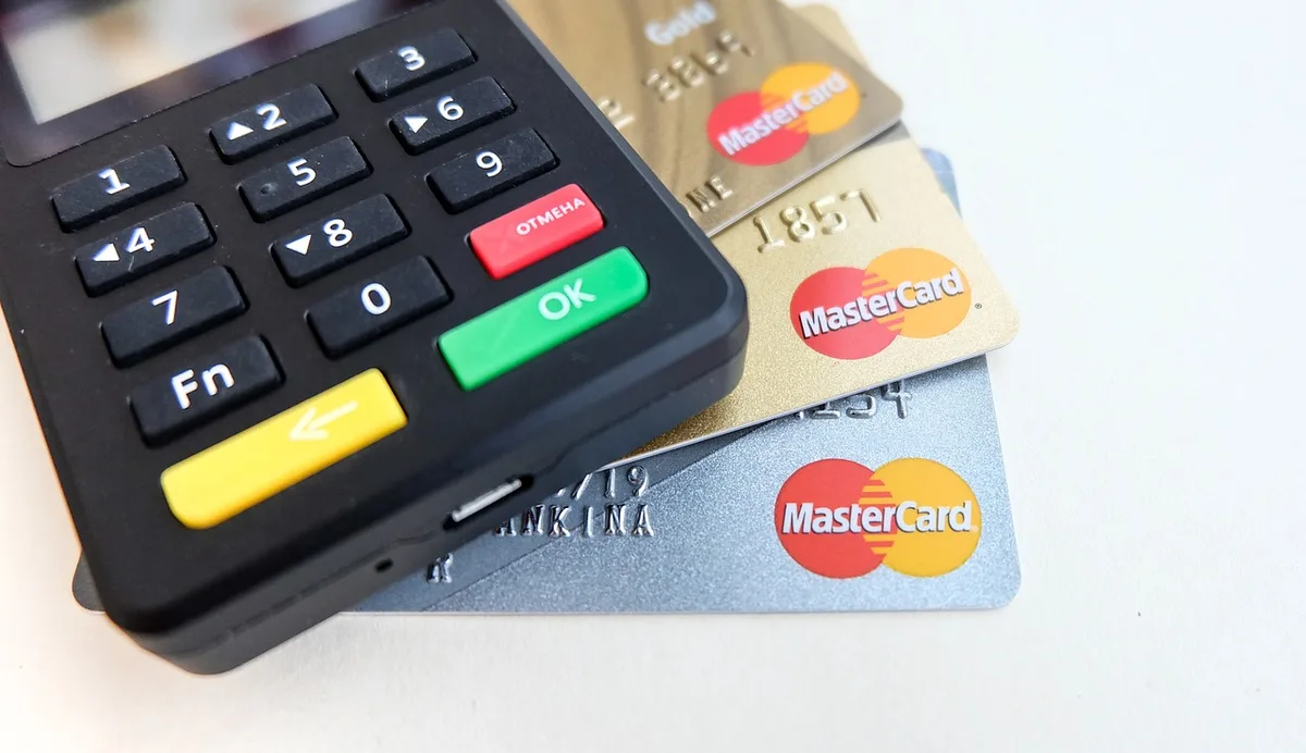 Mains près d'un terminal et d'un carnet de volumes de ventes