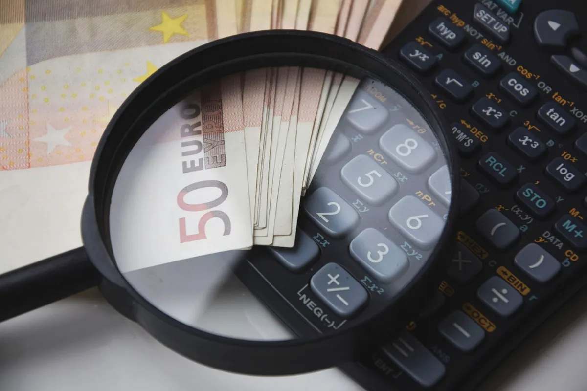 Documents de calcul fiscal et calculatrice sur un bureau éclairé par la lumière du jour