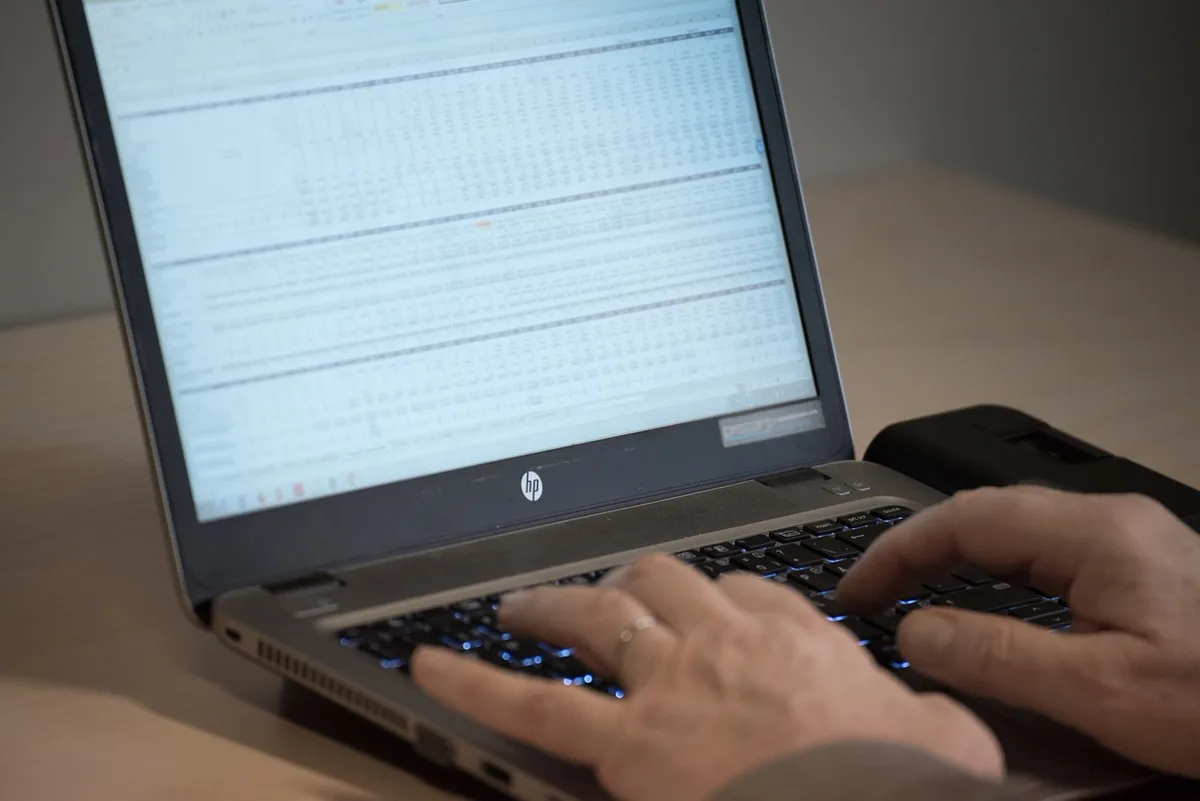 Tableau de rapprochement bancaire écrit sur feuille avec calculatrice