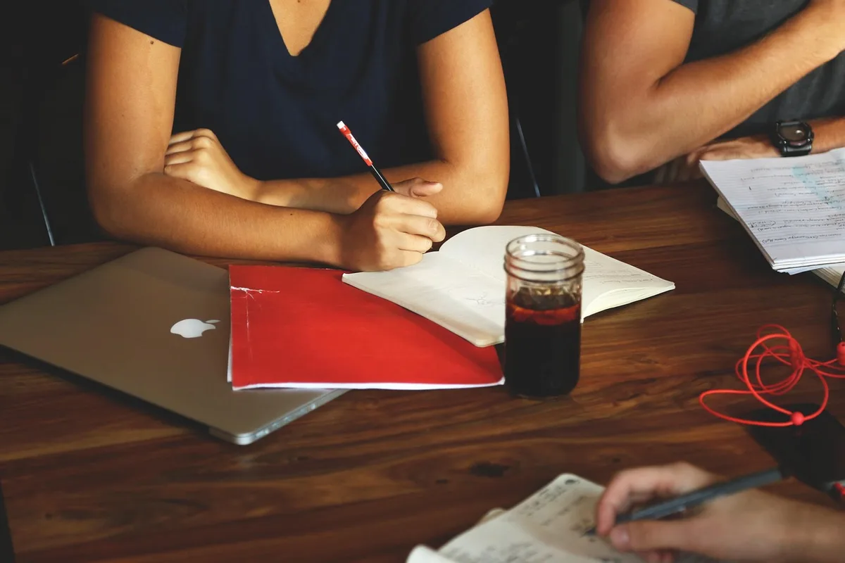 Groupe de jeunes en séance de brainstorming près d'une fenêtre en journée