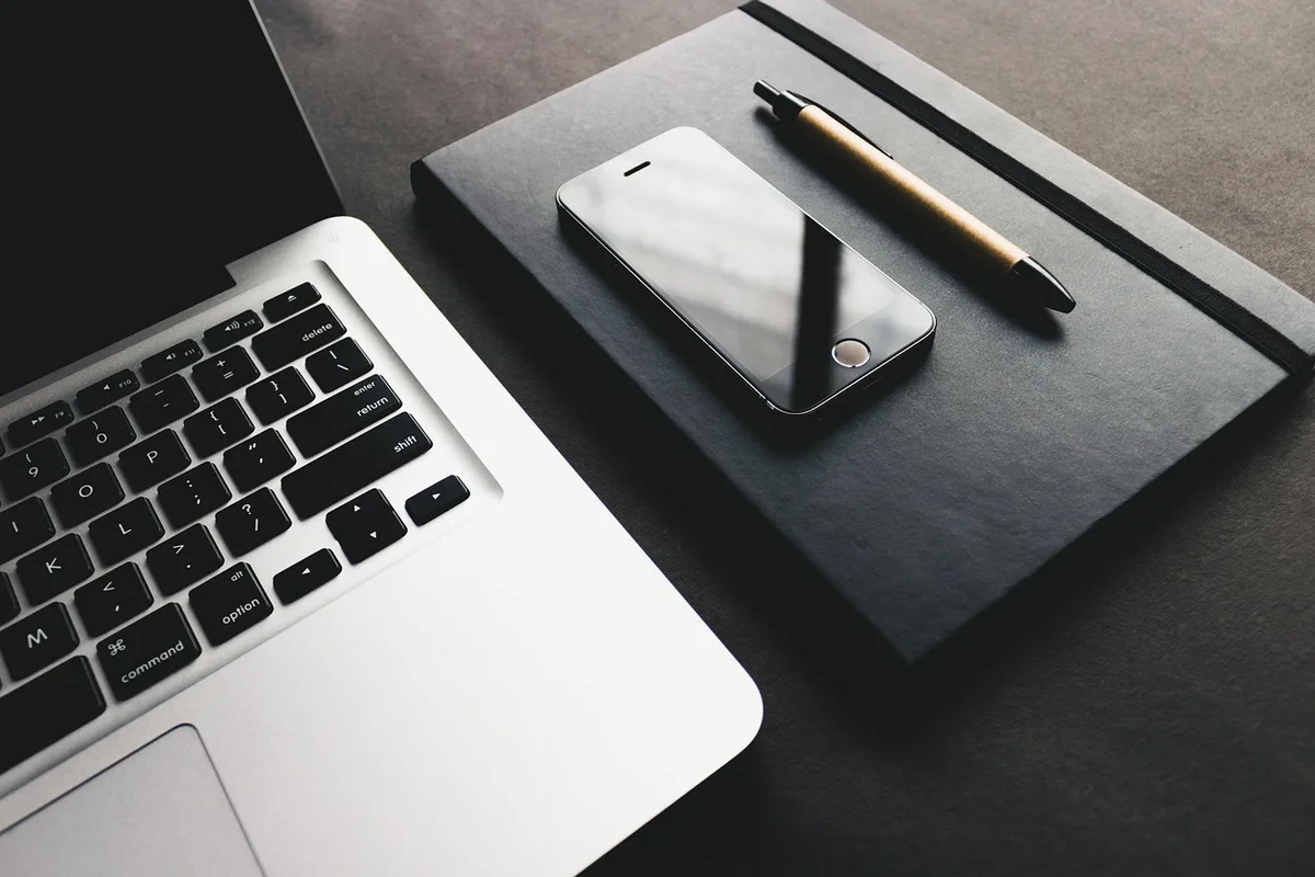 Ordinateur portable ouvert montrant un fichier CSS et un bureau en journée