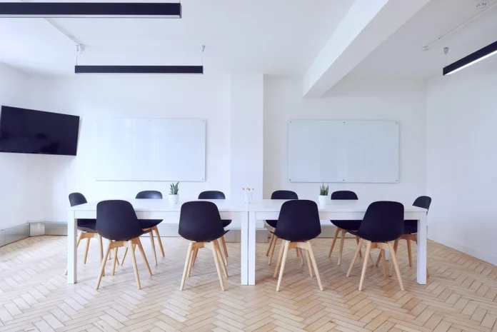 Salle associative en journée : table ronde avec carnets et tasses, lumière naturelle Salle associative en journée : table ronde avec carnets et tasses, lumière naturelle