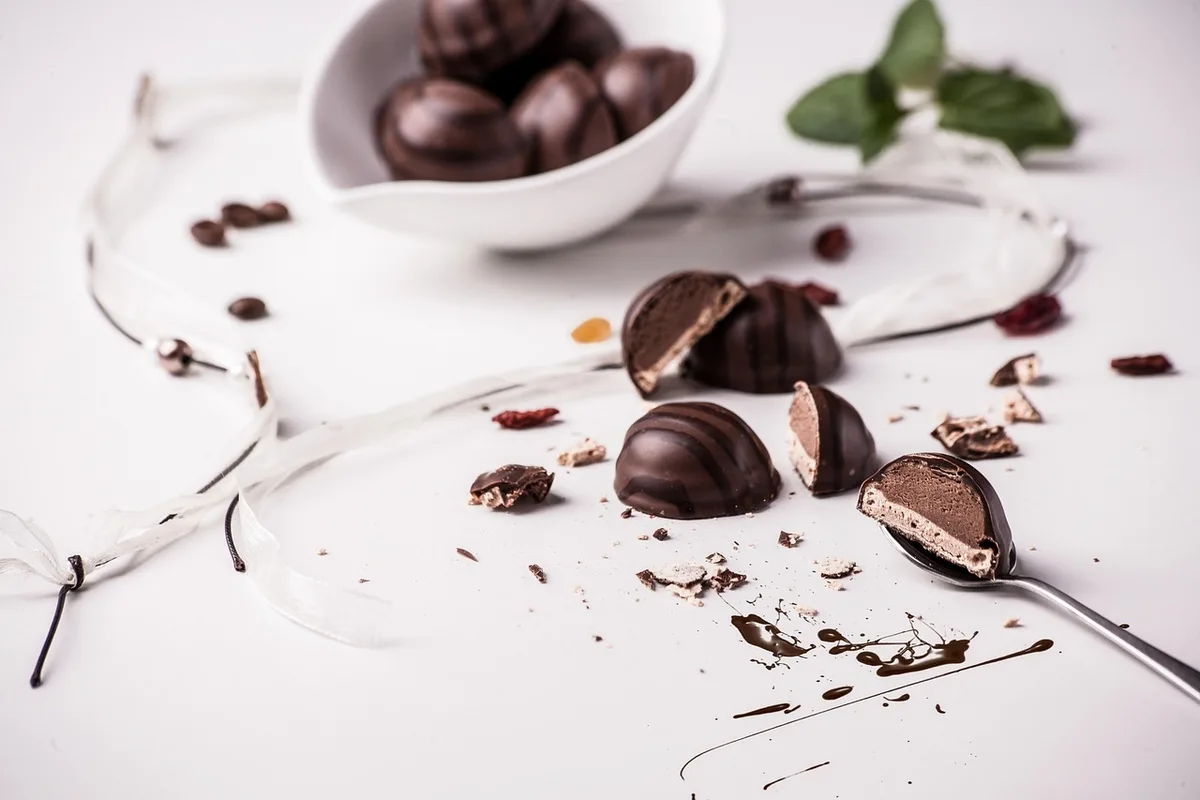 Vitrine de chocolaterie avec assortiments saisonniers et étiquettes de précommande