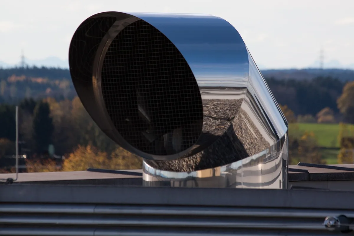 Salon avec traces d'humidité près d'une grille de ventilation