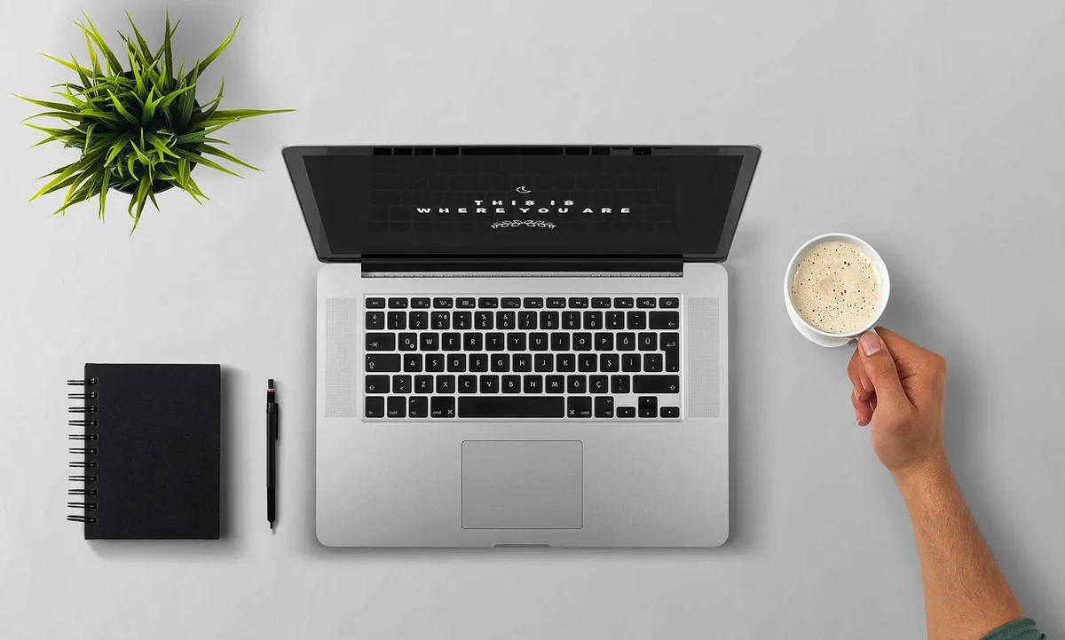 Locataire rédigeant une lettre au bailleur avec photos et documents sur le bureau