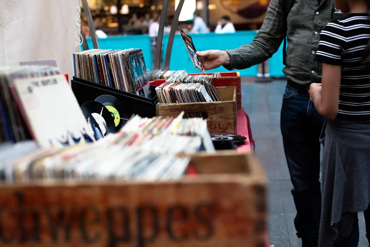 Vendeur sur un marché utilisant un terminal de paiement portable en extérieur