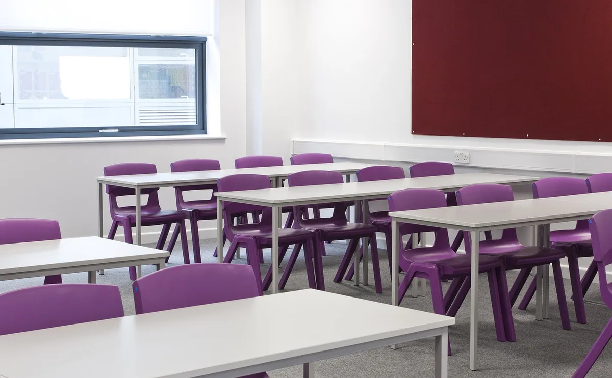 Salle de formation vide avec chaises et table, lumière du jour