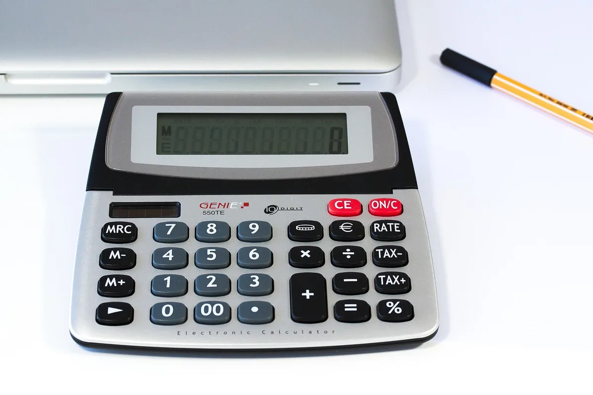 Calculatrice et fiches de paie sur un bureau pour le calcul des heures
