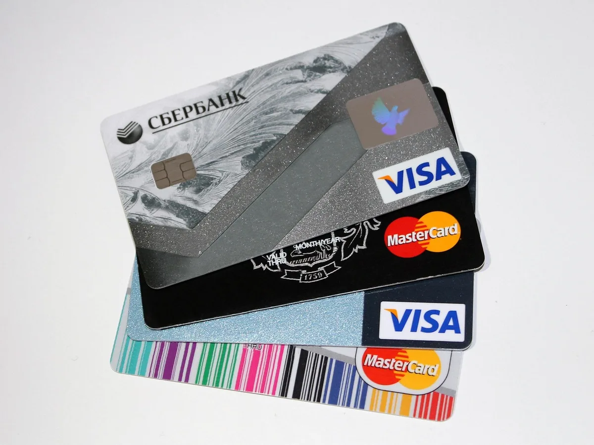 Carte bancaire posée près d'un terminal de paiement avec affichage de devises
